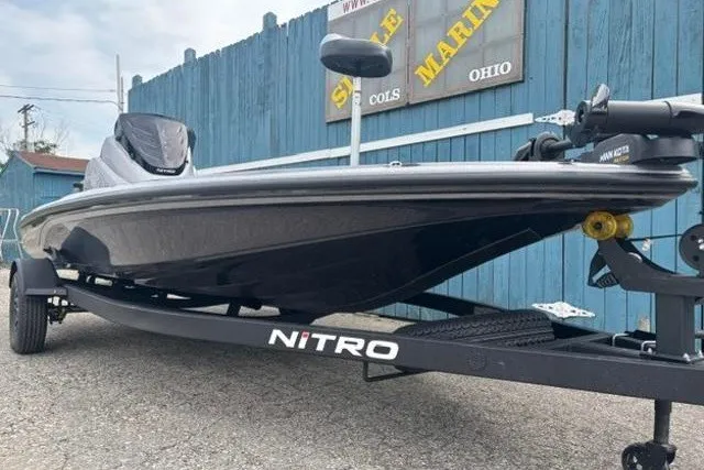 Slide: The Image of 2026 Nitro Z17 boat on trailer, parked near blue fence at marina. - 3