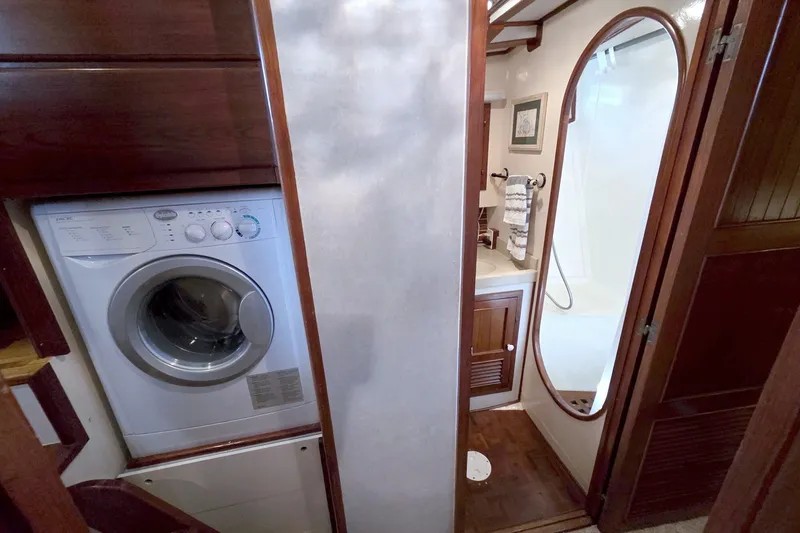 Slide: The Image of Laundry area and bathroom in a 1980 Kadey-Krogen 42 yacht, featuring a washing machine. - 65