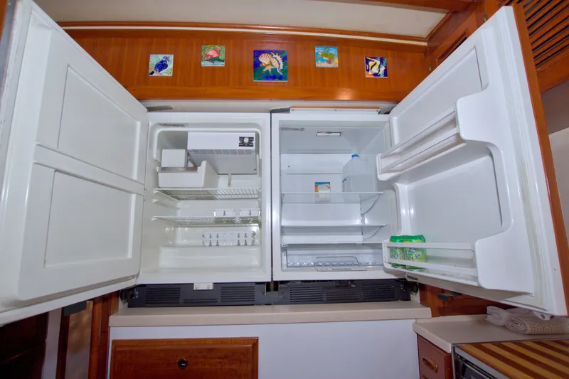 Slide: The Image of Open refrigerator in 1980 Kadey-Krogen 42 yacht kitchen, featuring colorful tile artwork above. - 45