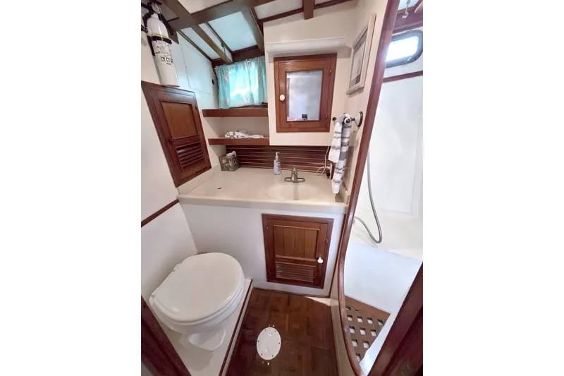 Slide: The Image of Kadey-Krogen 42 yacht bathroom, 1980 model, featuring wooden cabinetry and compact design. - 66