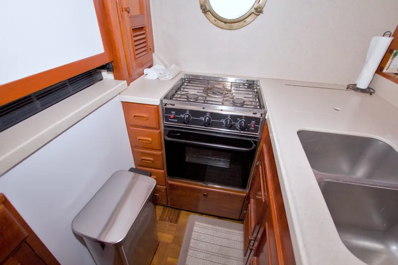 Slide: The Image of Compact kitchen in a 1980 Kadey-Krogen 42 boat with stove, sink, and storage. - 44