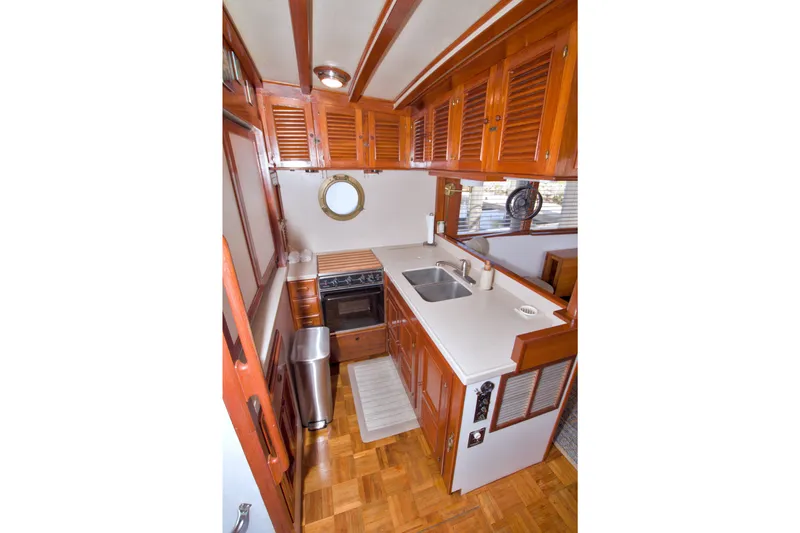 Slide: The Image of 1980 Kadey-Krogen 42 yacht kitchen with wooden cabinets and modern appliances. - 43