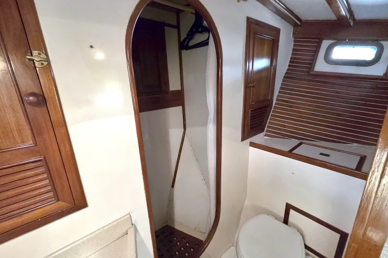 Slide: The Image of 1980 Kadey-Krogen 42 yacht bathroom with wooden cabinetry and porthole window. - 74