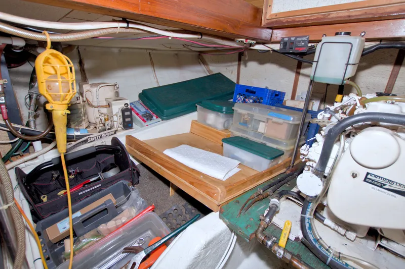 Slide: The Image of Engine room of a 1980 Kadey-Krogen 42 boat with tools and storage containers. - 98