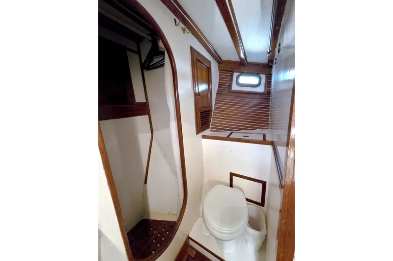 Slide: The Image of 1980 Kadey-Krogen 42 yacht bathroom with wooden accents and a small window. - 75