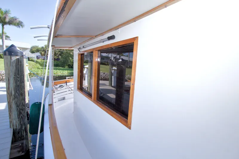 Slide: The Image of Side view of a 1980 Kadey-Krogen 42 yacht docked, showcasing wooden window frames. - 36