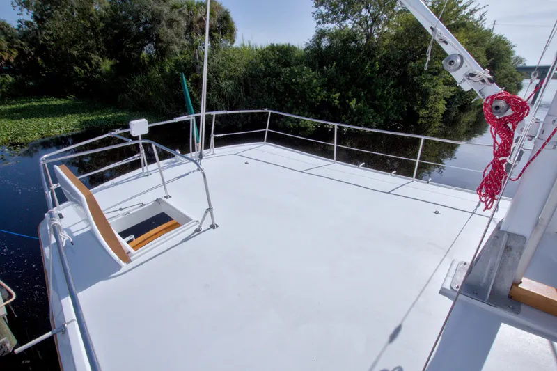 Slide: The Image of Deck of 1980 Kadey-Krogen 42 boat with railing and lush greenery backdrop. - 20