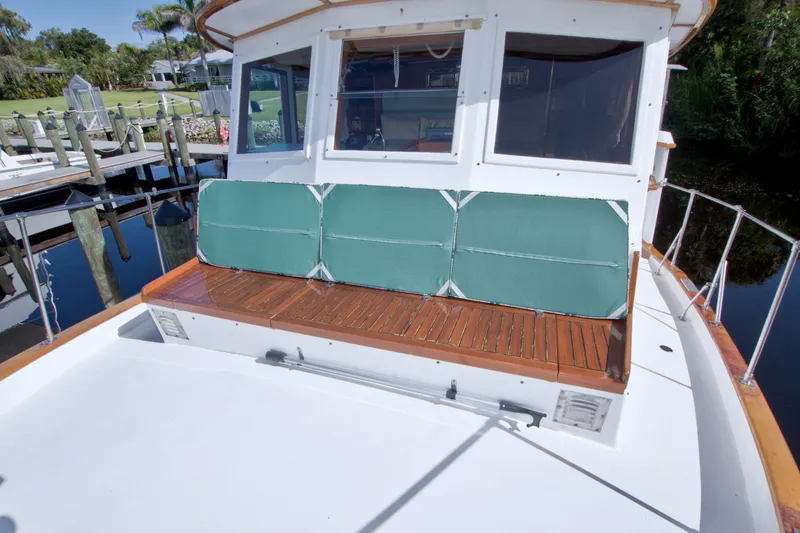 Slide: The Image of 1980 Kadey-Krogen 42 boat with wooden deck and green cushioned seating. - 31