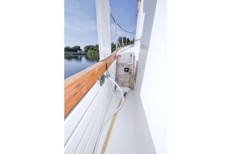 Slide: The Image of Side deck view of 1980 Kadey-Krogen 42 boat with wooden railings and water hose. - 25