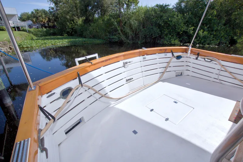 Slide: The Image of Cockpit of 1980 Kadey-Krogen 42 boat, featuring wooden trim and serene water backdrop. - 37