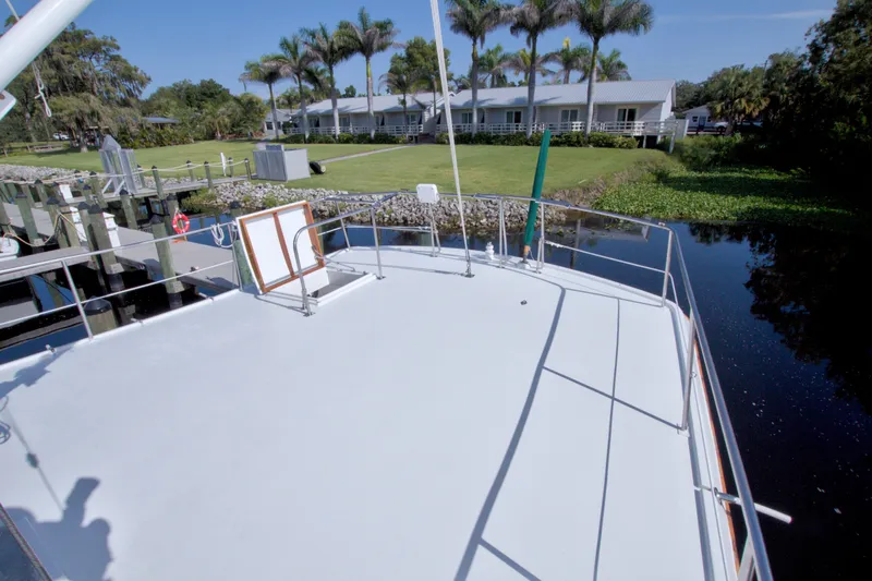 Slide: The Image of Kadey-Krogen 42 yacht deck, 1980 model, docked near lush greenery and palm trees. - 19