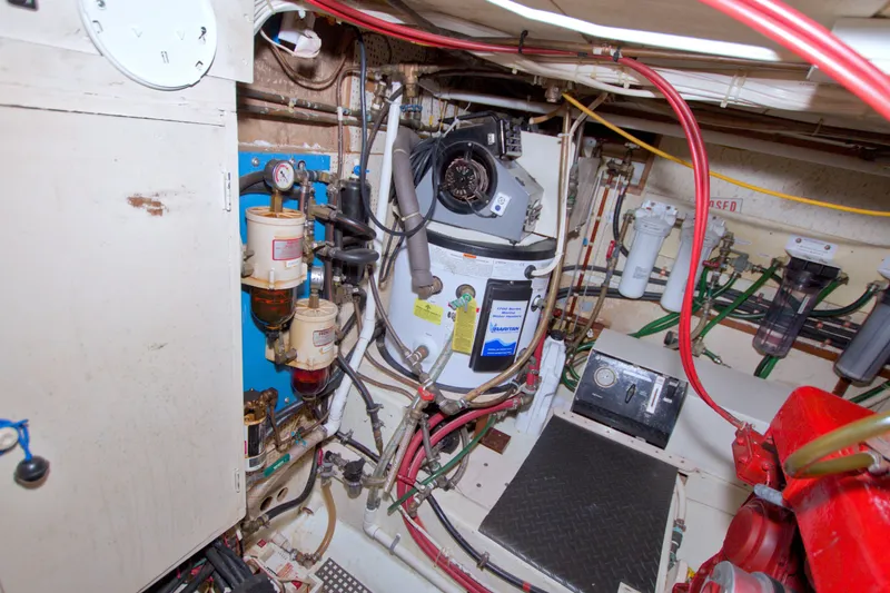 Slide: The Image of Engine room of a 1980 Kadey-Krogen 42 boat with mechanical components and wiring. - 79