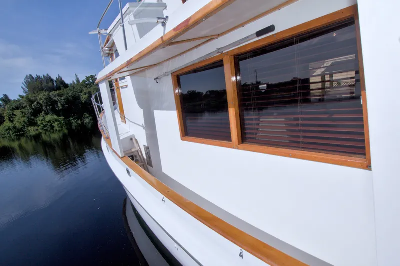 Slide: The Image of 1980 Kadey-Krogen 42 yacht side view on calm water, showcasing wooden accents and windows. - 24