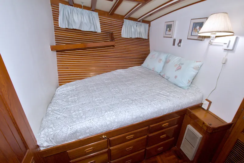 Slide: The Image of Cozy bedroom in 1980 Kadey-Krogen 42 yacht with wooden accents and soft lighting. - 69