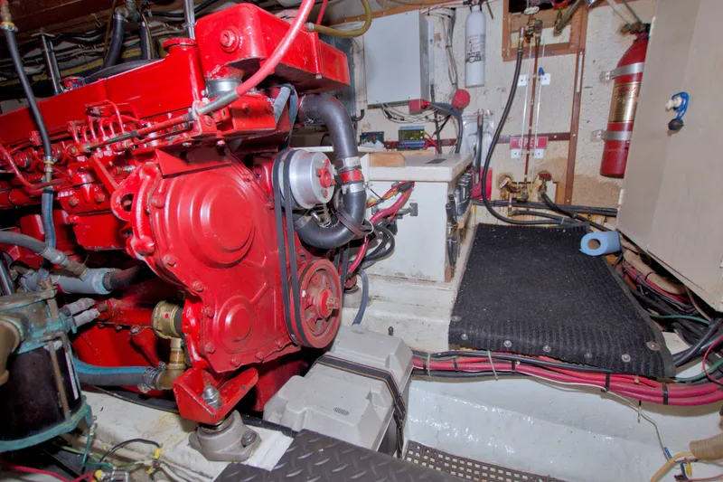 Slide: The Image of Engine room of a 1980 Kadey-Krogen 42 boat with red machinery and equipment. - 92