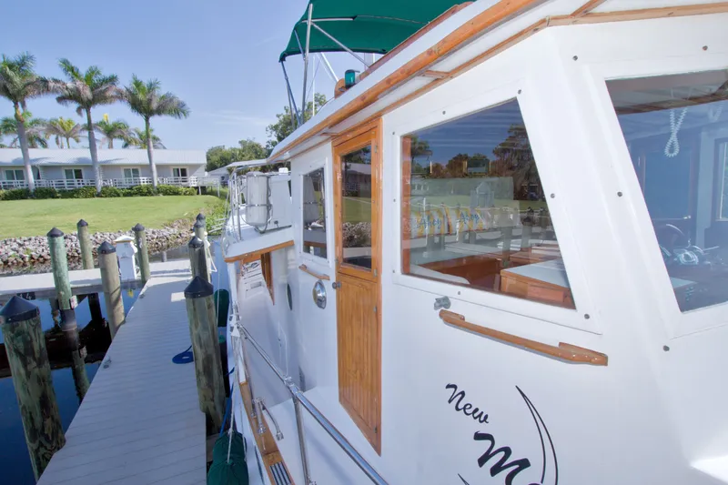 Slide: The Image of 1980 Kadey-Krogen 42 yacht docked, showcasing wooden accents and marina setting. - 33