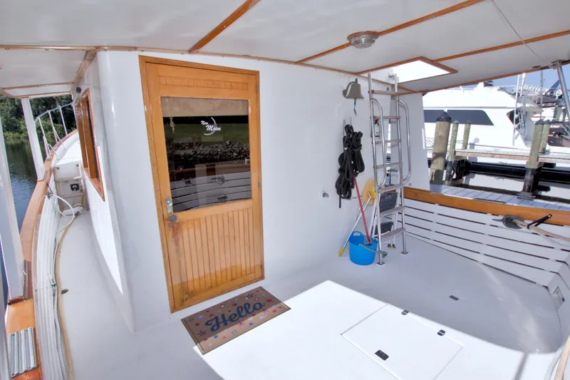 Slide: The Image of 1980 Kadey-Krogen 42 yacht deck with wooden door, ladder, and cleaning supplies. - 22