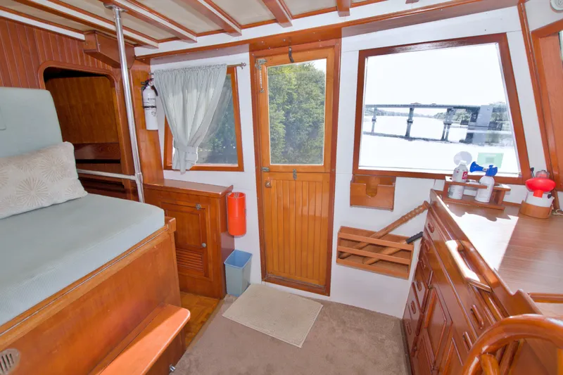 Slide: The Image of Cozy interior of a 1980 Kadey-Krogen 42 boat with wooden furnishings and river view. - 58