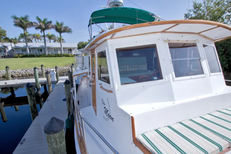Slide: The Image of 1980 Kadey-Krogen 42 yacht docked near palm trees and waterfront homes. - 32