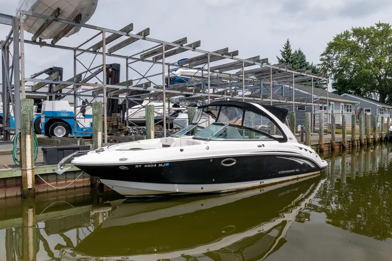 The Image of 2011 Chaparral 287 SSX boat docked at a marina, featuring sleek black and white design. - 0