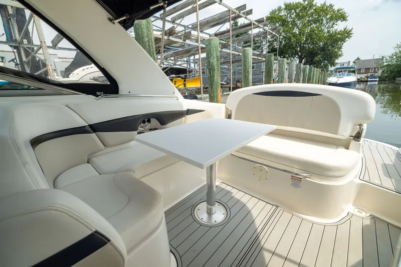 Slide: The Image of Interior of 2011 Chaparral 287 SSX boat with seating and table, docked by water. - 13