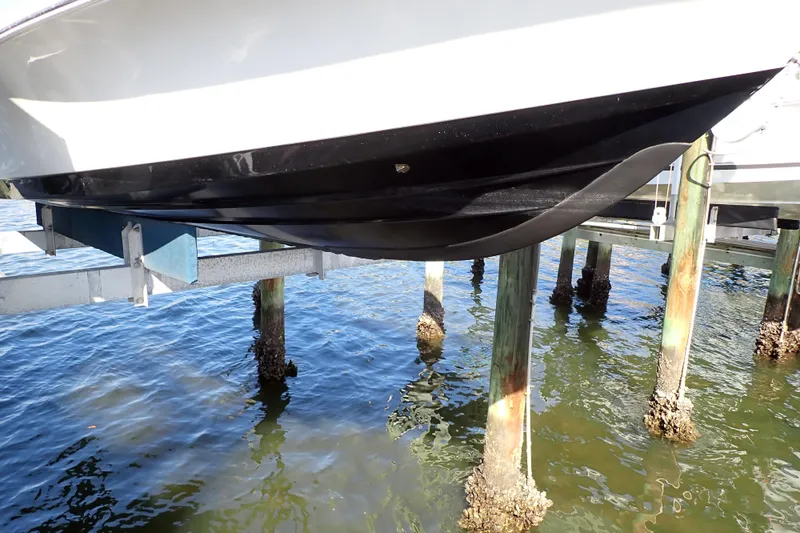 Slide: The Image of 2015 Blue Wave 2400 PureBay boat hull on lift above water. - 95