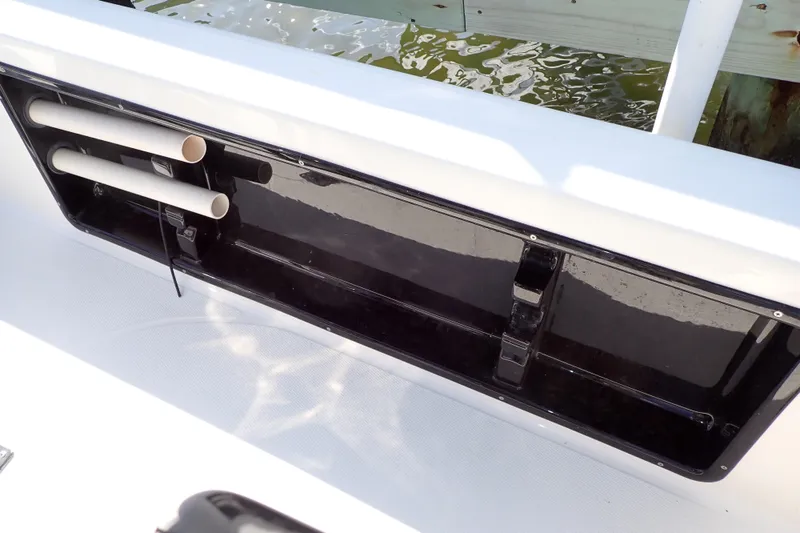 Slide: The Image of 2015 Blue Wave 2400 PureBay boat storage compartment with rod holders, dockside view. - 61