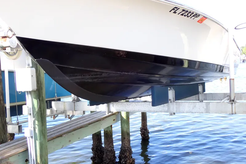 Slide: The Image of 2015 Blue Wave 2400 PureBay boat on lift, showcasing hull design and registration number. - 102