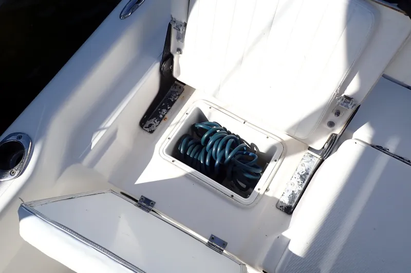 Slide: The Image of 2015 Blue Wave 2400 PureBay boat interior with storage compartment and coiled hose. - 65