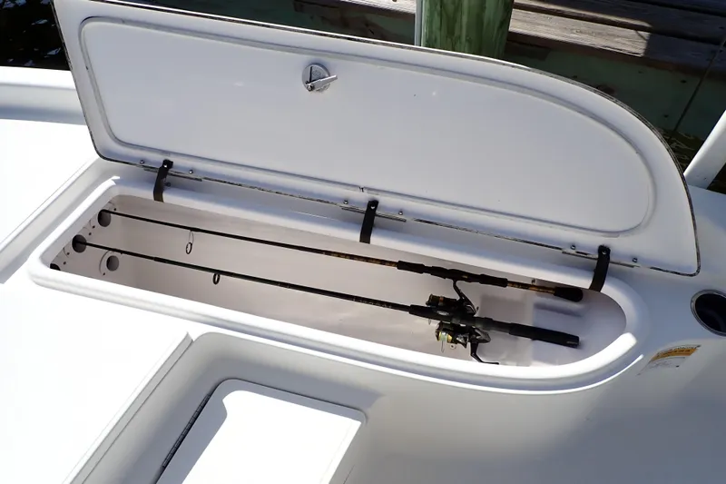 Slide: The Image of Open storage compartment on 2015 Blue Wave 2400 PureBay boat with fishing rods inside. - 49