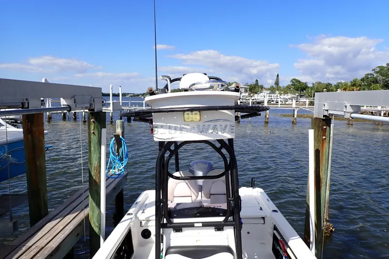 Slide: The Image of 2015 Blue Wave 2400 PureBay boat docked at a marina under a clear blue sky. - 19