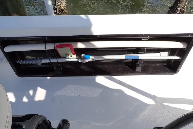 Slide: The Image of Storage compartment on a 2015 Blue Wave 2400 PureBay boat, holding various tools and equipment. - 62