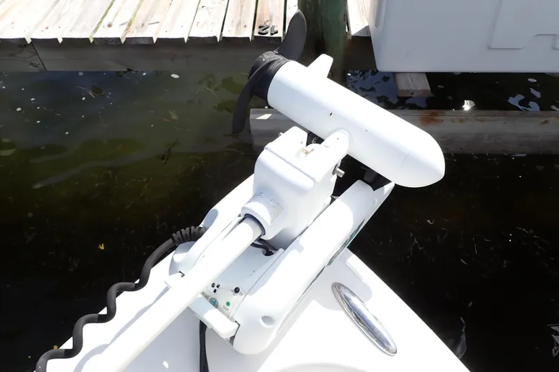 Slide: The Image of Trolling motor on a 2015 Blue Wave 2400 PureBay boat docked by wooden pier. - 22
