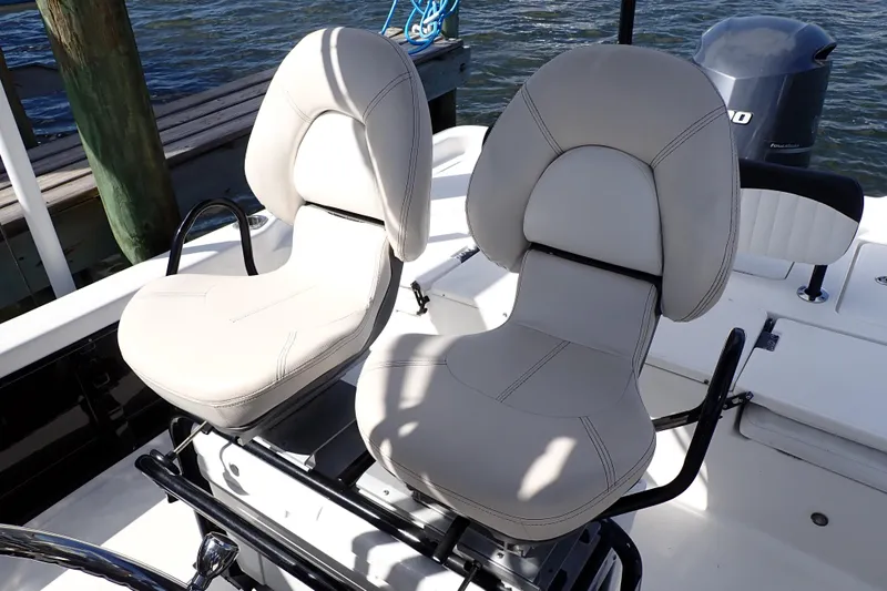 Slide: The Image of Dual captain chairs on 2015 Blue Wave 2400 PureBay boat, docked by water. - 16