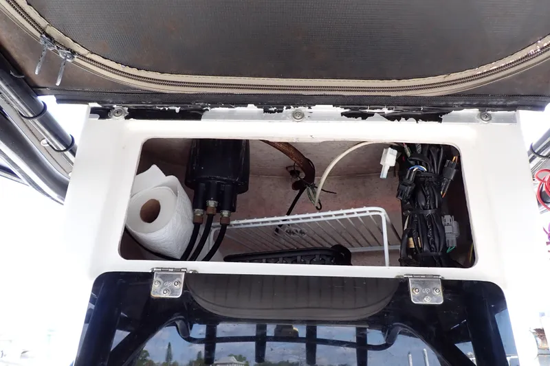 Slide: The Image of Storage compartment in a 2015 Blue Wave 2400 PureBay boat, featuring wiring and a paper towel roll. - 56