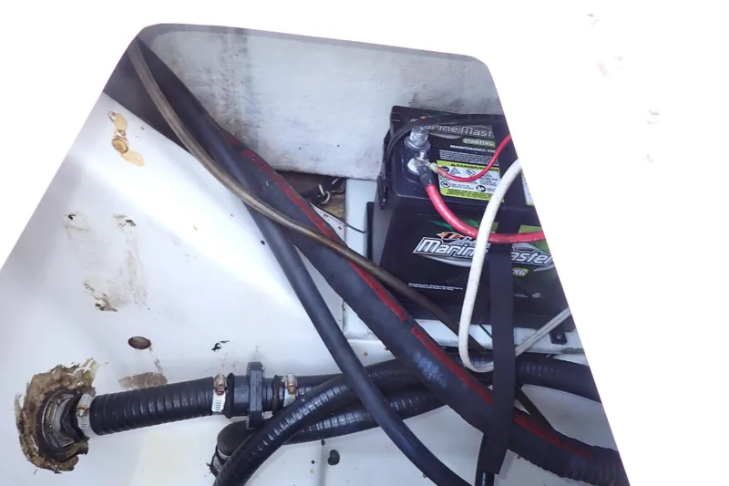 Slide: The Image of Battery compartment of a 2015 Blue Wave 2400 PureBay boat with visible wiring and hoses. - 76