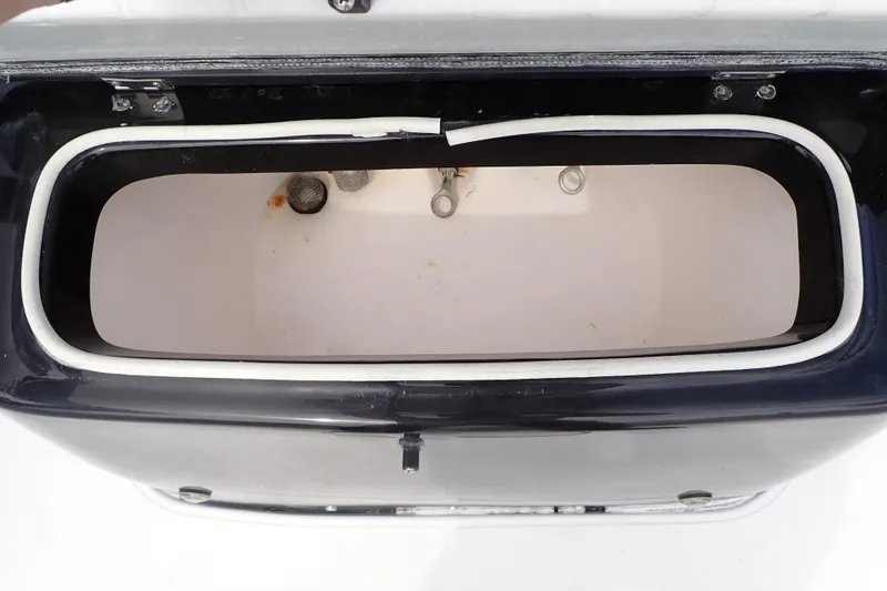 Slide: The Image of Livewell compartment of a 2015 Blue Wave 2400 PureBay boat, featuring a clean interior. - 52