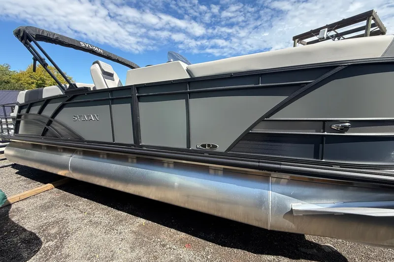 Slide: The Image of 2026 Sylvan L-3 LZ DH pontoon boat with sleek design under a blue sky. - 36