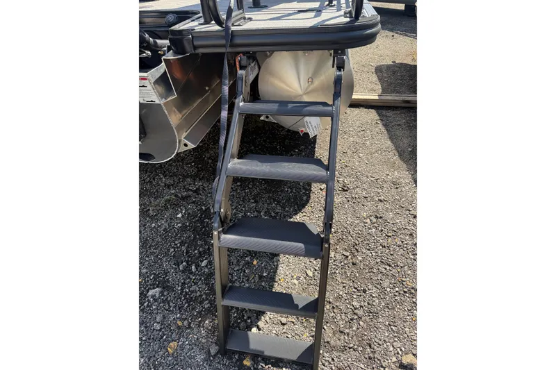 Slide: The Image of Ladder on 2026 Sylvan L-3 LZ DH boat, resting on gravel surface. - 34