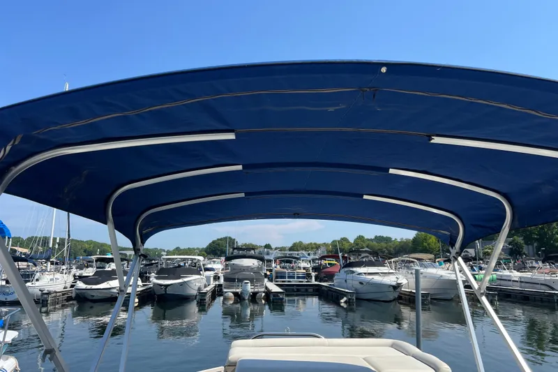 Slide: The Image of 2007 Starcraft Elite 226 RE CR boat with blue canopy docked at marina. - 16