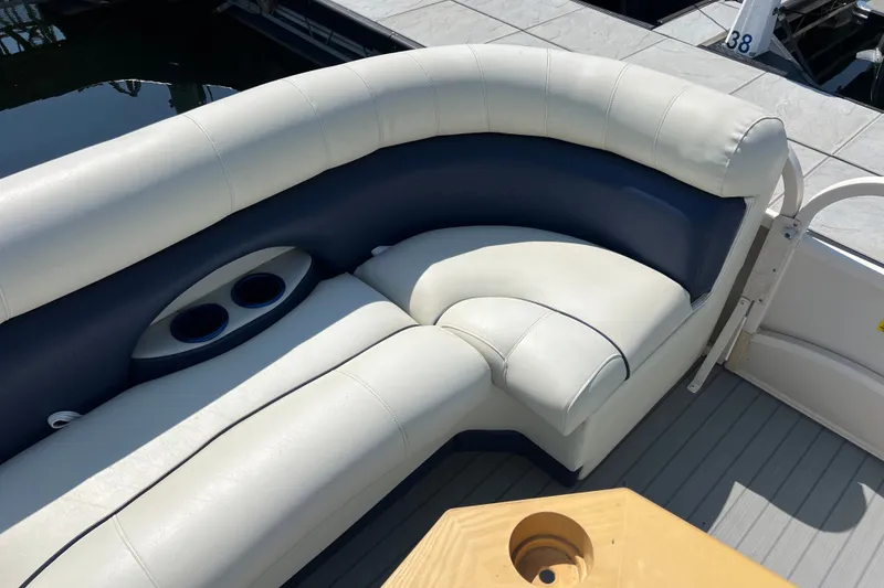 Slide: The Image of 2007 Starcraft Elite 226 RE CR boat interior with cushioned seating and cup holders. - 13
