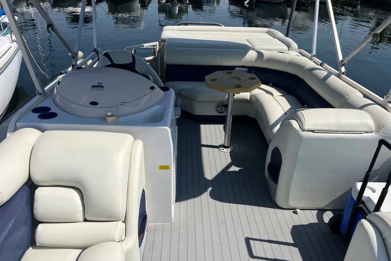 Slide: The Image of 2007 Starcraft Elite 226 RE CR pontoon boat interior with seating and table on water. - 15