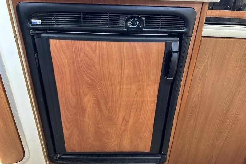 Slide: The Image of Wood-paneled refrigerator in 2004 Bayliner 3055 Ciera Sunbridge boat interior. - 27