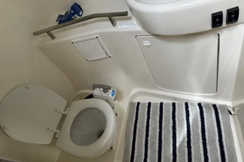 Slide: The Image of Bathroom interior of 2004 Bayliner 3055 Ciera Sunbridge with striped rug and toilet. - 17