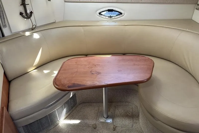 Slide: The Image of 2004 Bayliner 3055 Ciera Sunbridge interior with beige seating and wooden table. - 37