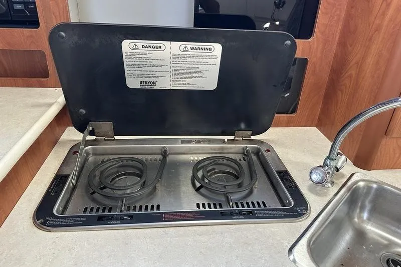 Slide: The Image of 2004 Bayliner 3055 Ciera Sunbridge kitchen with stove and sink. - 29