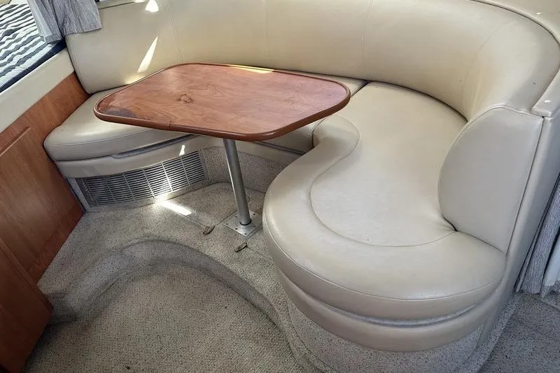 Slide: The Image of 2004 Bayliner 3055 Ciera Sunbridge interior with beige seating and wooden table. - 30