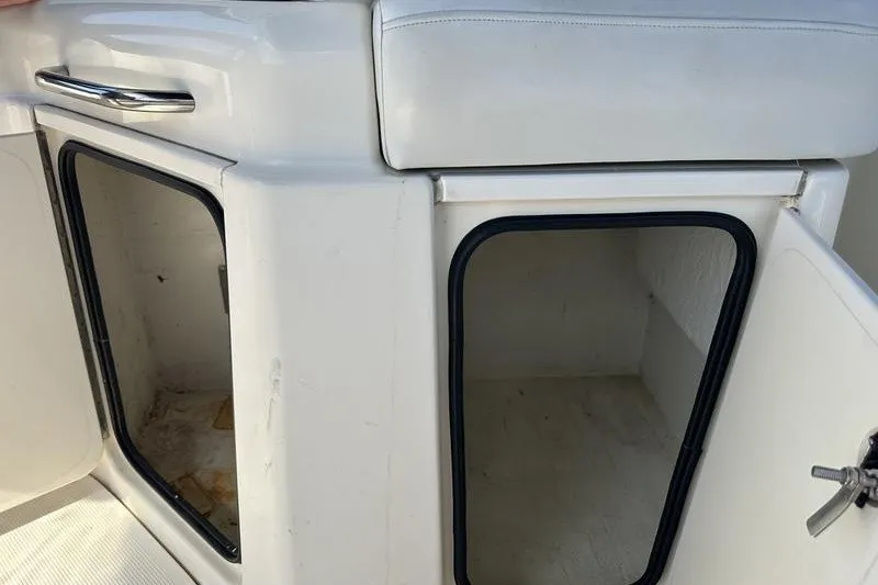Slide: The Image of 2004 Bayliner 3055 Ciera Sunbridge storage compartments with open doors and white seating. - 23