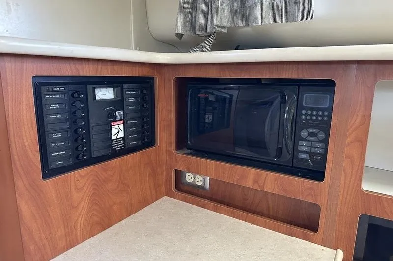 Slide: The Image of 2004 Bayliner 3055 Ciera Sunbridge interior with microwave and control panel. - 28