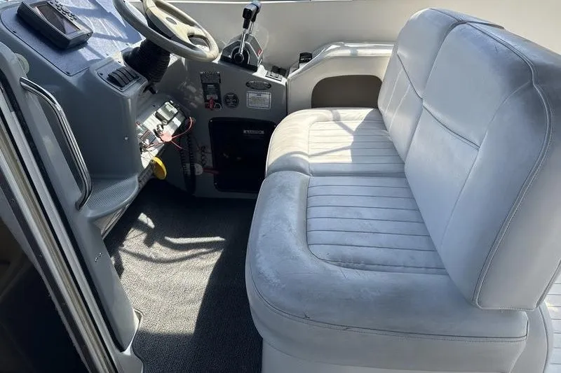 Slide: The Image of 2004 Bayliner 3055 Ciera Sunbridge cockpit with white seating and steering controls. - 20